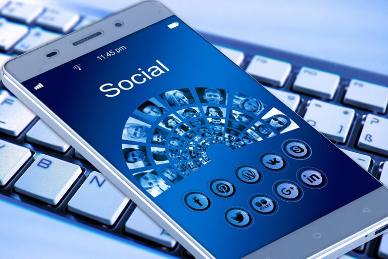 Mână care ține un telefon pe care se vede semnalul rețelei, pe fundal estompat de oraș