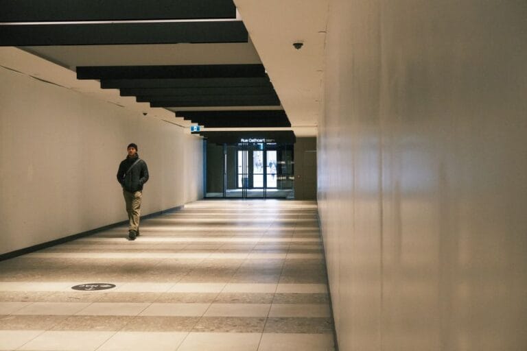 Un coridor luminos dintr-o clădire publică, cu uși de toalete și pardoseală curată